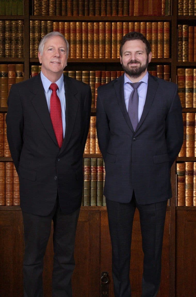 Attorneys William R. Van Order and Conor P. O'Brien standing in front of a bookcase of bound law reports.