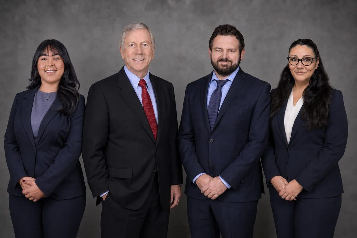 The firm's four-person team in dark suits: attorneys William R. Van Order and Conor P. O'Brien at the centre, with the paralegal and case manager and the administrative assistant on either side.